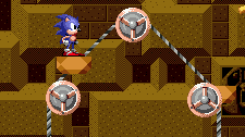 Turning wheels and chains carry around a series of small platforms, which can be used to get from A to B. Be careful of being brought up toward spikes in the ceiling though.
