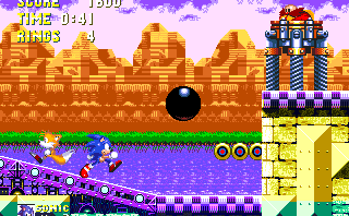 In this first boss, Eggman remains stationary at the top of a ledge. On the wall of that ledge, a small hatch of three circles opens up to act as a platform. Unfortunately it also throws out a giant, harmful bowling ball, either from above or below it.