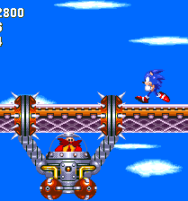 Eggman swings in, in a kind of monkey-like contraption. As he hangs, he slowly edges towards you with his spiked claws, and toasts you with a top-mounted flame thrower if you're careless enough to stand in between them.