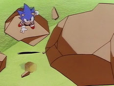 Sonic is stopped by the sight of a giant chain and falling rocks, and he immediately leaps and spins between them to climb a tall spire and investigate.